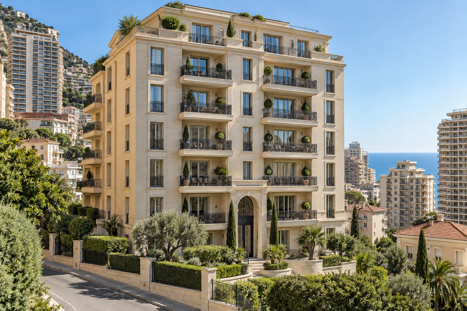 Cream-coloured apartment building with balconies, dense Mediterranean surroundings and the sea in the background